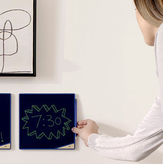 Woman attaching magnetic stylus to side of wall mounted VersaTile