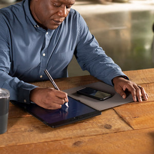 Man in an office setting writing on a Blackboard Letter with Blackboard Smart Pen